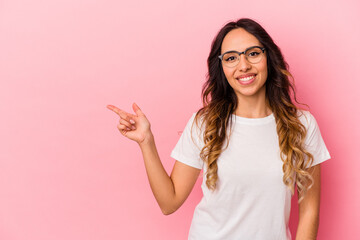 Young mexican woman isolated on pink background smiling cheerfully pointing with forefinger away.