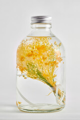 瓶に入ったオイル漬けの黄色の花（ハーバリウム）