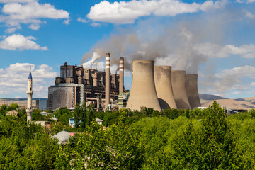Steaming cooling towers on green meadow