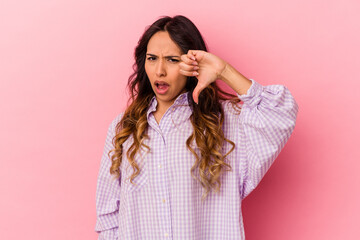 Fototapeta premium Young mexican woman isolated on pink background showing thumb down and expressing dislike.