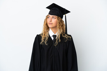 Young university graduate isolated on white background looking to the side