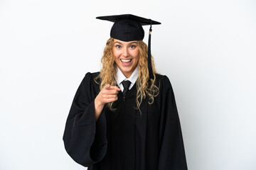 Young university graduate isolated on white background surprised and pointing front
