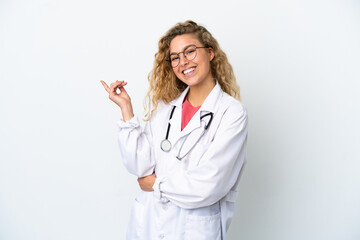 Young doctor blonde woman isolated on white background pointing finger to the side