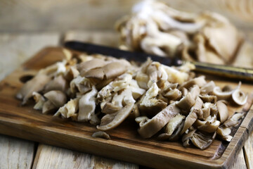 Sliced oyster mushrooms on a wooden board.