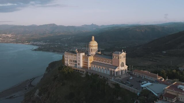 Aerial orbital shot of Sanctuary of Tindari 
from high angle view at sunset, iconic Sicily travel destinations in Italy 2/2