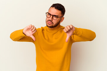 Young caucasian man isolated on white background showing thumb down, disappointment concept.