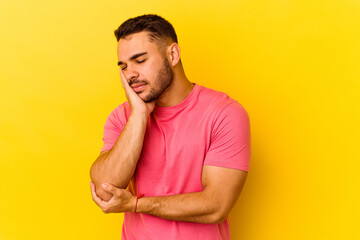 Young caucasian man isolated on yellow background who is bored, fatigued and need a relax day.