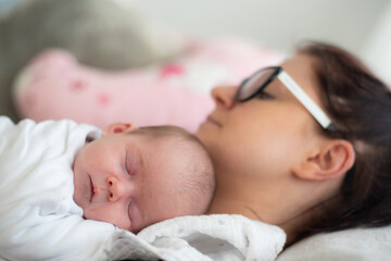 A mother is lying with the newborn baby. Motherhood concept