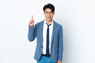 Young Chinese business man isolated on white background pointing up a great idea