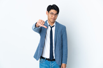 Young Chinese business man isolated on white background showing thumb down with negative expression