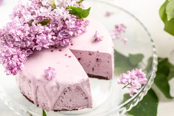 Fototapeta na wymiar velvet mousse cake with blueberries decorated with a bouquet of purple blooming lilac, French cuisine, postcard, background