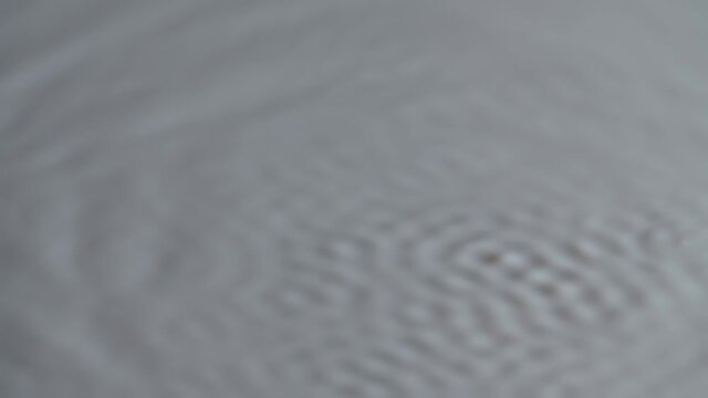 Vibration and resonance. Distribution of sound waves on the white surface of milk. Circles and ripples of milky fluid when excited by vibration at different frequencies. Slow motion. Close up.