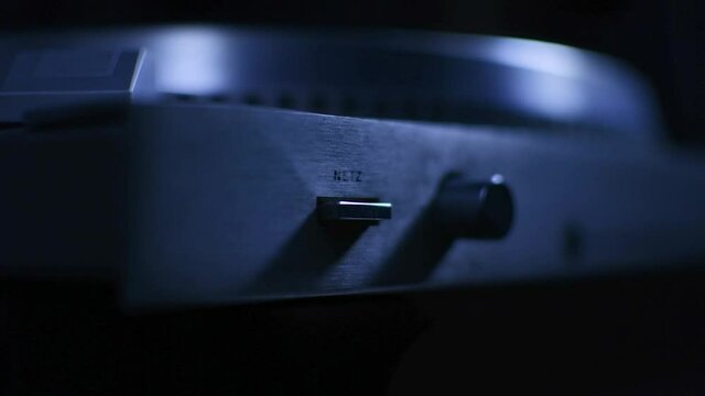 Male hand pushing button on record player. Close-up. 