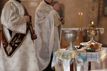 MYKOLAIV, UKRAINE - FEBRUARY 27, 2021: Deacon and priest conducting baptism ceremony in...