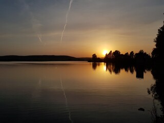 Evening orange sun is reflected in the pond