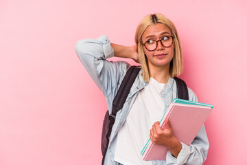 Young venezuelan student woman isolated on pink background touching back of head, thinking and making a choice.