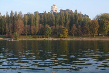 The river Po in Turin photographed by the Murazzi. On the river with the calm and blue waters, the Monte dei Capuccini rises on the Turin hill.