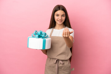 Little girl with a big cake over isolated pink background inviting to come with hand. Happy that you came
