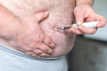 close up of fat man hands making injection with insulin pen or syringe, medicine, diabetes,...