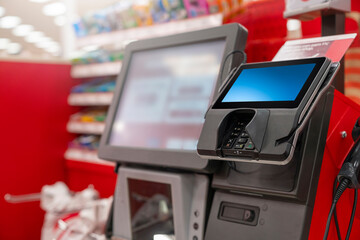 A POS machine at Woolworths Supermarket's self-serve checkout area with blur bokeh background - obrazy, fototapety, plakaty