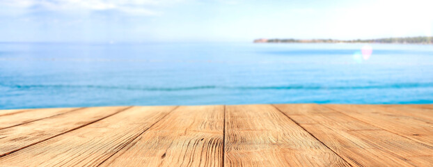 Fototapeta premium A wooden table on a beautiful sunny holiday day with a charming sea landscape 