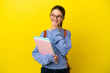 Student kid woman over isolated yellow background looking to the side and smiling