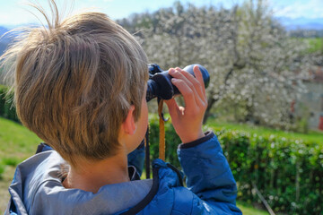 Boy watching the view with binocular. Hands holding binocular close-up. Travel, tourism. Future planning concept