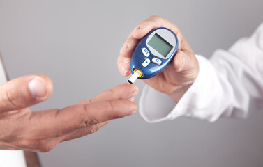 Doctor measuring glucose level in patient.