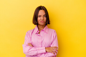 Young mixed race woman isolated on yellow background unhappy looking in camera with sarcastic expression.