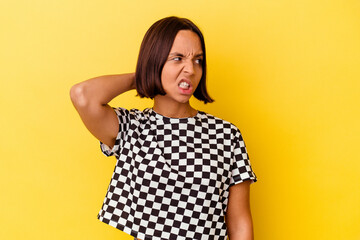 Young mixed race woman isolated on yellow background tired and very sleepy keeping hand on head.