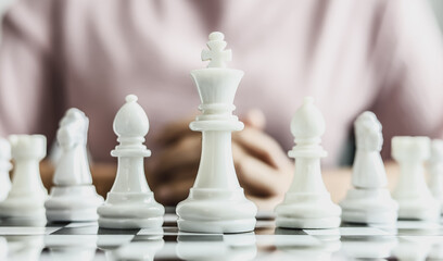 White chess pictures laid out on a chessboard, concept comparing playing chessboard to business administration. Businessmen playing chess are likened to business planning and problem-solving.