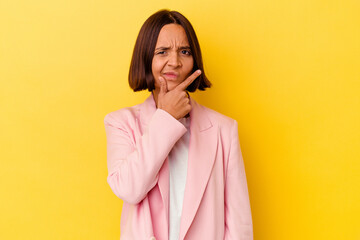 Young mixed race woman isolated on yellow background contemplating, planning a strategy, thinking about the way of a business.