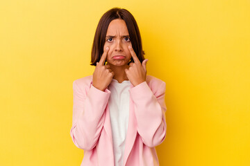 Young mixed race woman isolated on yellow background crying, unhappy with something, agony and confusion concept.