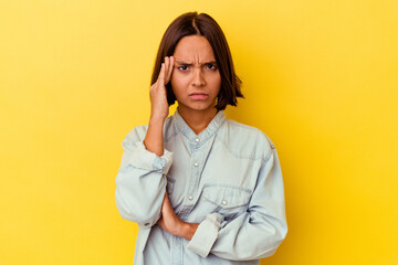 Young mixed race woman isolated on yellow background blows cheeks, has tired expression. Facial...