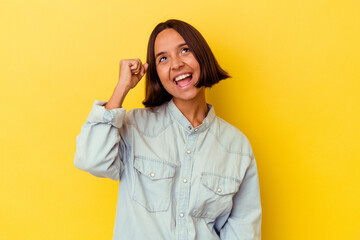 Young mixed race woman isolated on yellow background celebrating a victory, passion and enthusiasm, happy expression.