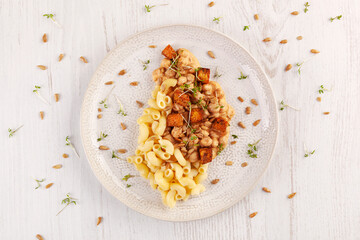 Tasty pasta with chickpeas, tofu and fresh herbs from above.