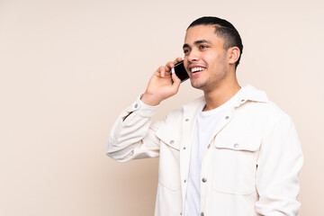 Asian handsome man over isolated background keeping a conversation with the mobile phone