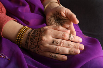 Woman with beautiful henna tattoos on hands, closeup. Traditional mehndi