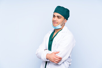 Surgeon man with uniform isolated on blue background looking to the side