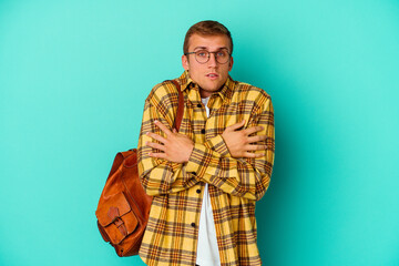 Young caucasian student man isolated on blue background