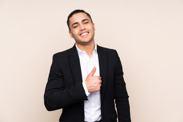 Asian business man isolated on beige background giving a thumbs up gesture