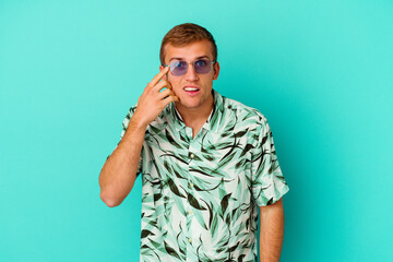 Young caucasian man wearing a summer clothes isolated on blue background