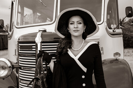 Vintage beautiful woman wearing hat standing next to retro bus