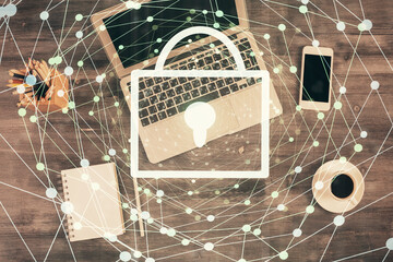 Double exposure of lock hologram drawing over study table background with computer. Concept of data security. Top view.