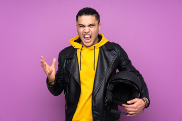 Man with a motorcycle helmet isolated on purple background unhappy and frustrated with something