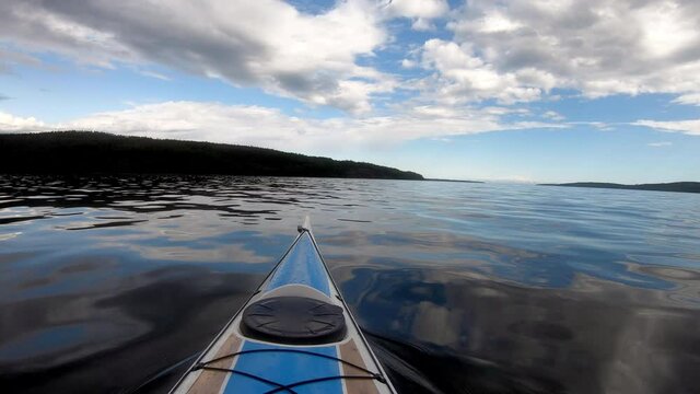 Brown and Blue Kayak softly bounces on the waves in the Night. Summertime on the Swedish ocean. Beautiful scenery. Blurred logo.