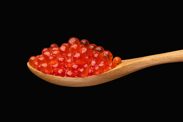 Red exclusive caviar on wooden spoon isolated on dark background