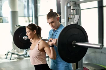 Dekokissen Young athletic woman exercising with barbell with help of personal trainer in a gym. © Drazen