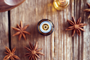 A bottle of star anise essential oil with dried star anise. Aromatherapy or alternative medicine concept.