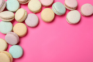 Delicious colorful macarons on pink background, flat lay. Space for text